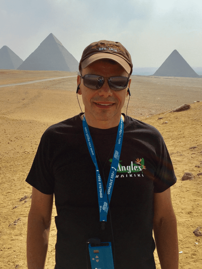 Man standing in front of Egyptian pyramids.
